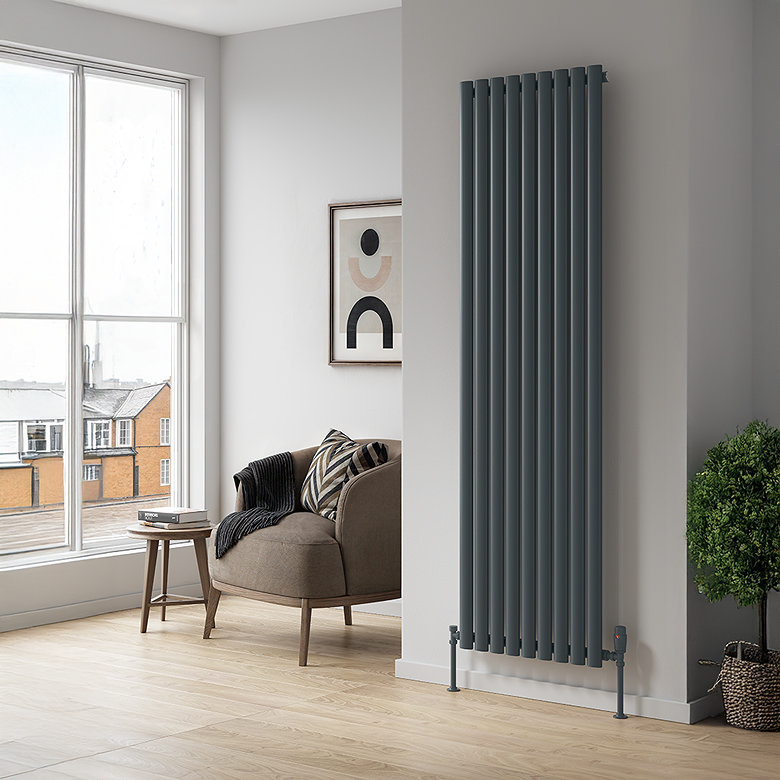 Tall anthracite vertical radiator mounted on a narrow wall in a modern living room