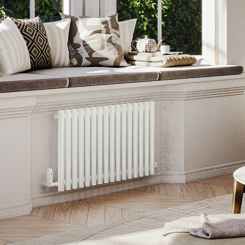 Modern white horizontal radiator fitted beneath a window seat in a bright living room