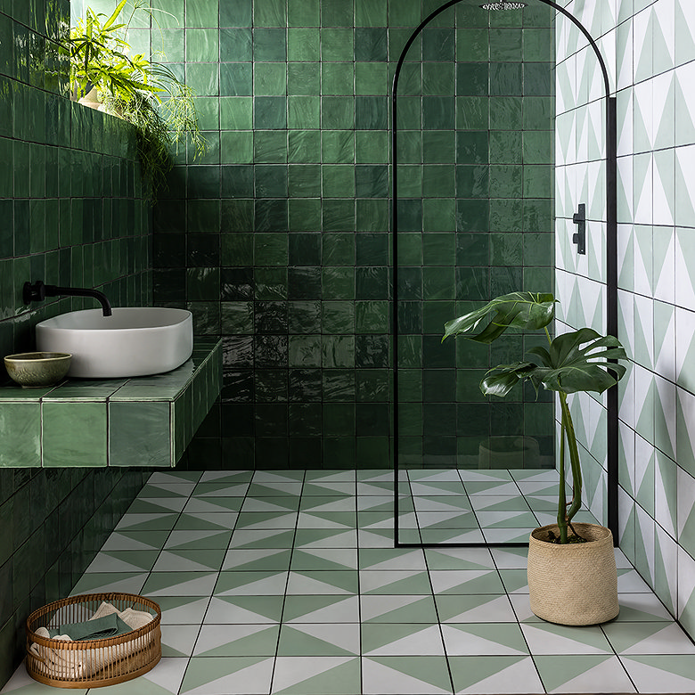 green geometric wall and floor tiles in bathroom