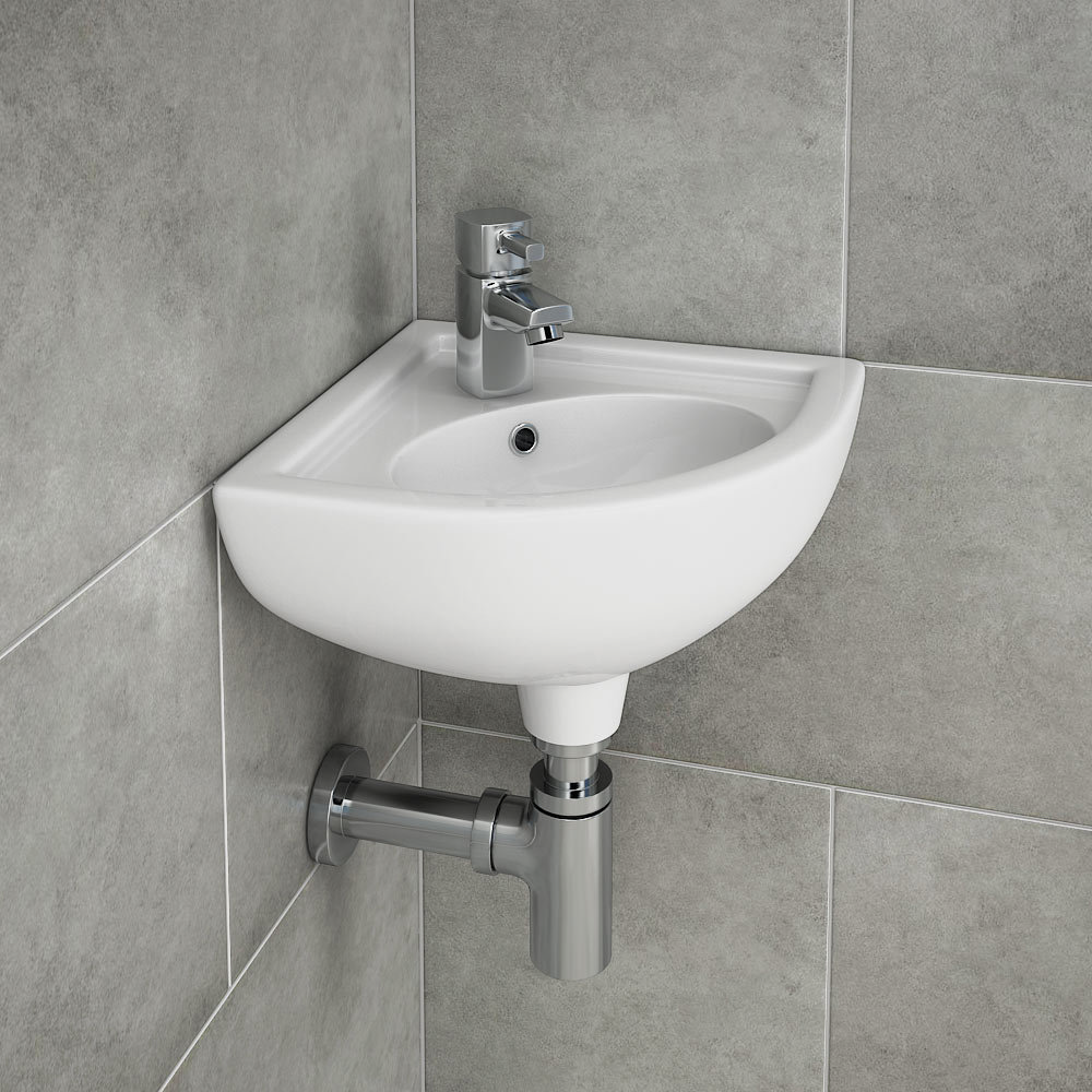 RAK Compact Corner Basin - COMCNRB1 - Close up image of chrome basin tap on a wall hung corner cloakroom basin set against grey tiles.