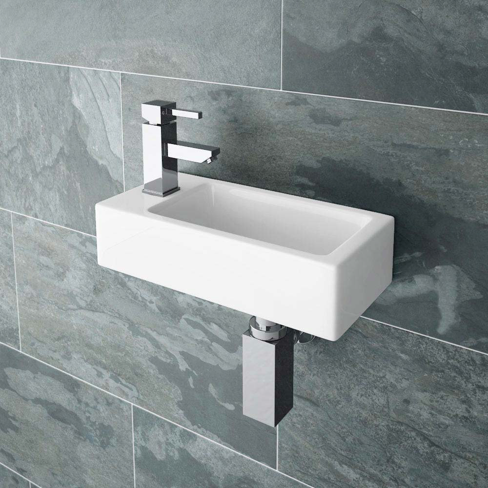 Rondo Wall Hung Small Cloakroom Basin - VES047 - Close up image of chrome basin tap on a wall hung cloakroom basin set against grey tiles.