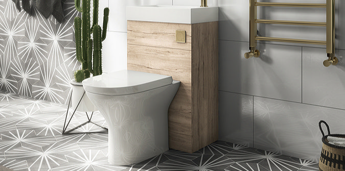 Modern white bathroom with a close-coupled toilet, pedestal sink, and bath, with wood accents and sleek tile walls.