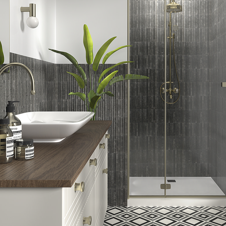 Bathroom with black fluted wall tiles, gold shower fittings and a white vessel sink on a wooden countertop.