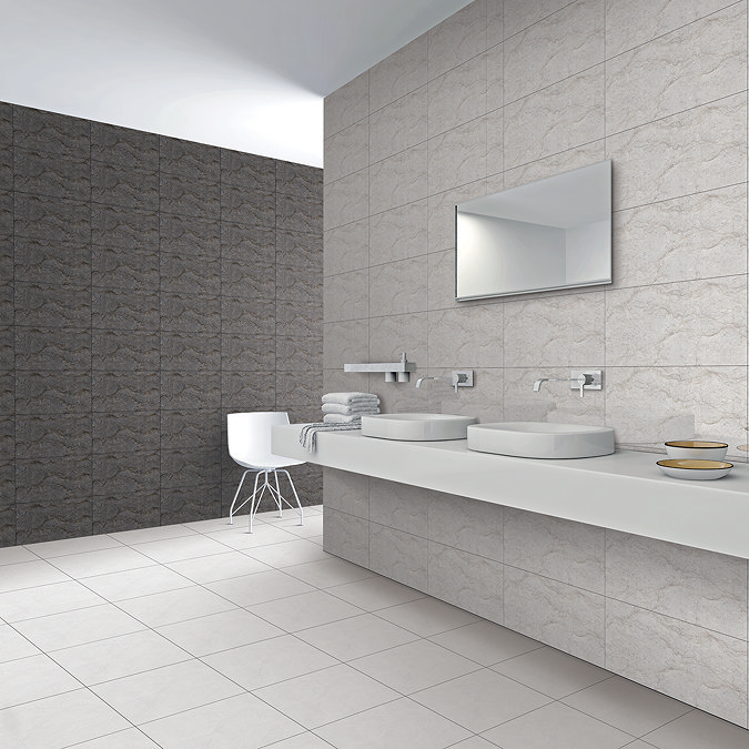 Minimalist bathroom with light stone-effect wall and floor tiles, featuring a floating vanity with dual countertop sinks and sleek chrome fixtures for a modern, spacious look.