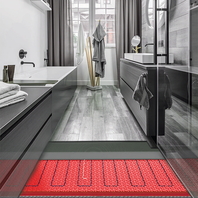 Modern bathroom with sleek wood-effect flooring, showcasing underfloor heating system with red heating elements beneath the surface. A minimalist design features a freestanding bathtub, dark vanity units, and large windows with grey curtains.