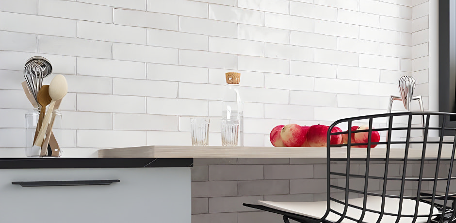 Warm white metro tiles with subtle variation behind a modern kitchen worktop.