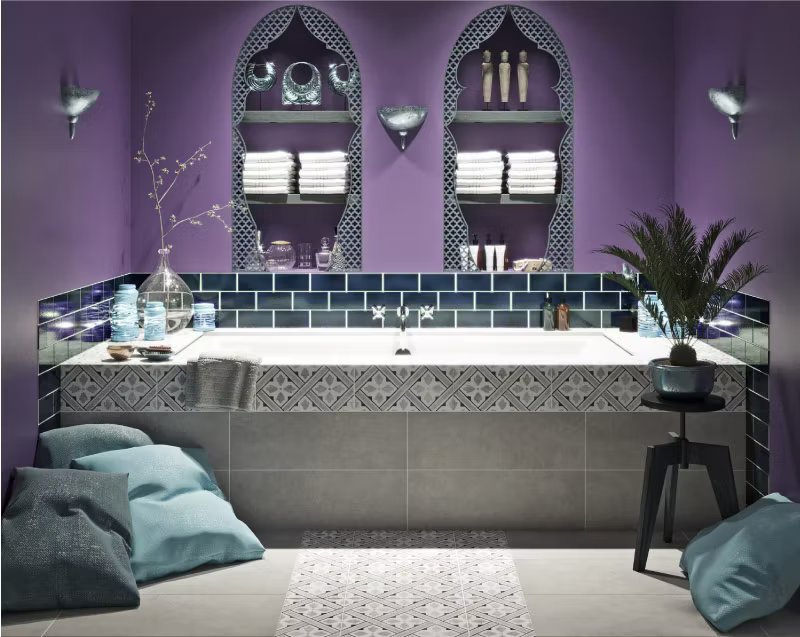 Moroccan-inspired bathroom with deep purple walls, decorative arch niches, and blue subway tiles around the built-in bathtub, creating a luxurious and exotic retreat.