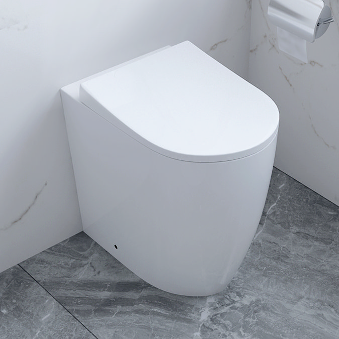 Compact modern back-to-wall toilet in a minimalist bathroom with marble flooring and walls