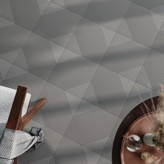 Overhead view of sleek geometric floor tiles with a grey, textured design featuring interlocking shapes and subtle lines. These modern, matte-finish tiles create a contemporary, minimalist look, perfect for adding depth and movement to any space.