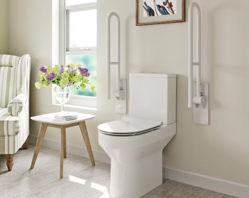 Accessible bathroom with a modern toilet featuring support rails on both sides for added stability, ideal for elderly or mobility-impaired users.