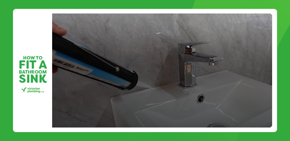Applying silicone sealant around a newly fitted bathroom sink