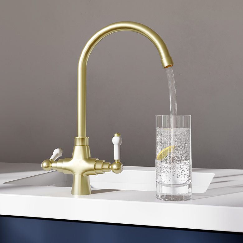 Brushed brass traditional tap pouring water into glass