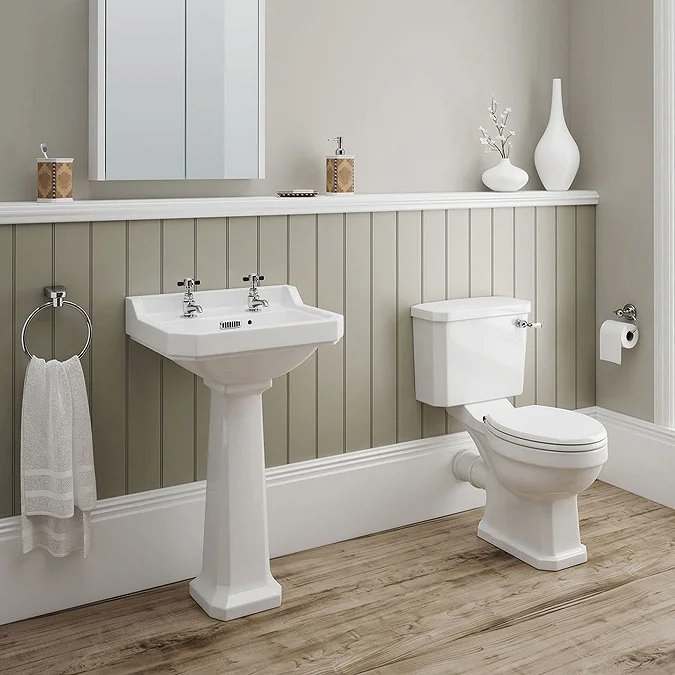 Classic bathroom with pedestal sink, white toilet, and wood-effect flooring