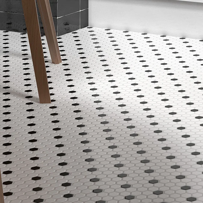 White hexagonal floor tiles with black diamond accents in a modern bathroom.