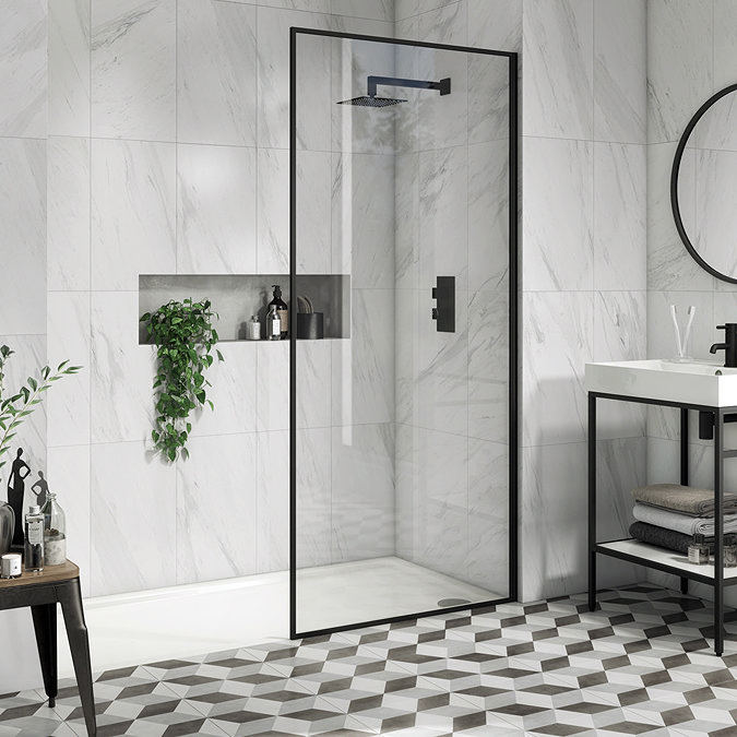 Modern bathroom with marble-effect wall tiles, black-framed glass shower, geometric pattern floor tiles, and a minimalist vanity with a round mirror.