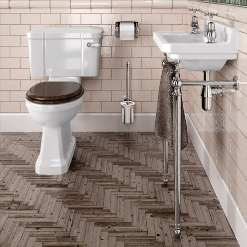 Slimline back to wall toilet in a small vintage-style bathroom with a traditional basin and wood-effect flooring