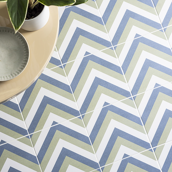 Blue and green geometric zigzag floor tiles paired with a modern side table and potted plant, adding a vibrant touch to the space.