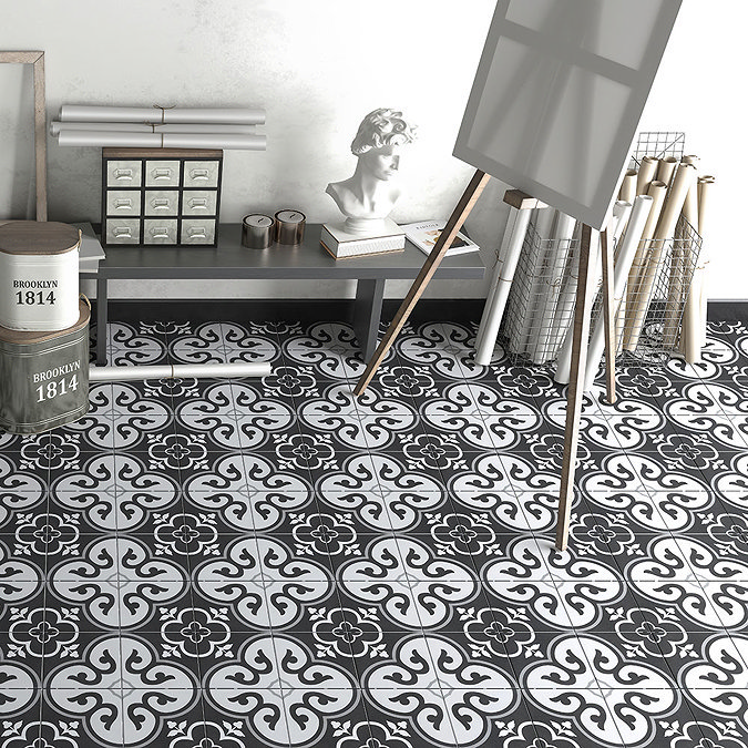 Workspace with vintage black and white patterned floor tiles, featuring a grey console table, art supplies, and decorative bust statue.