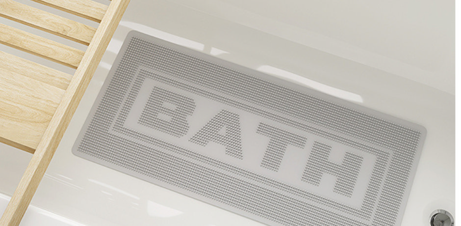 Close-up of a white anti-slip bath mat with “BATH” text, inside a bathtub with wooden bath rack.