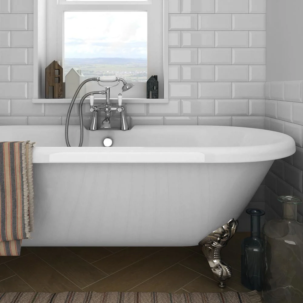 Classic freestanding bath with chrome claw feet, vintage-style tap, and white subway tile backdrop, offering a cosy, traditional bathroom setting.