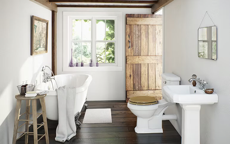 Charming country-style bathroom featuring a freestanding clawfoot tub, wooden barn door, and traditional white fixtures. Warm wooden accents and natural light create a cosy, rustic retreat.