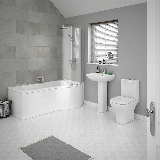 Modern bathroom with a P-shaped shower bath, white pedestal sink, and close-coupled toilet, featuring a minimalist design and grey tiled walls.