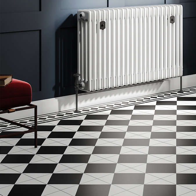 Black and white checkered bathroom floor tiles with a classic pattern, paired with a traditional white column radiator against a navy blue panelled wall. The vintage-inspired design adds timeless elegance to the room.