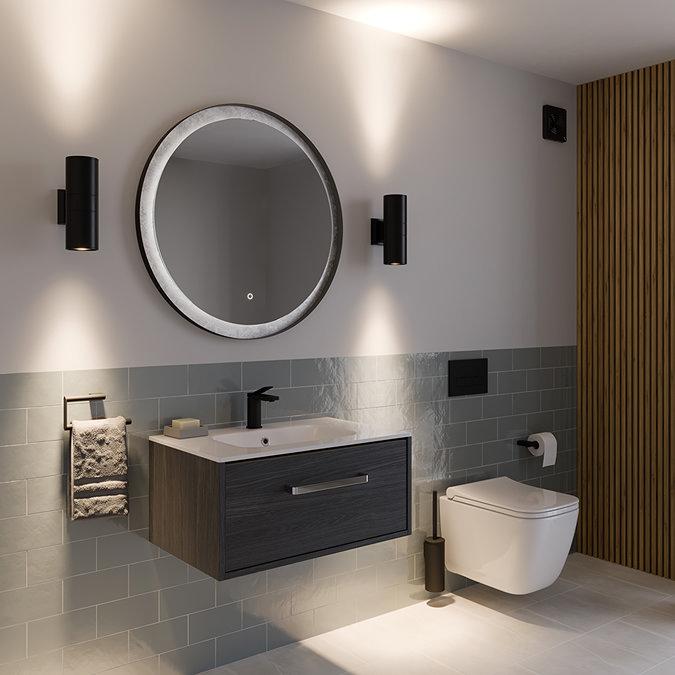 Modern bathroom design featuring a floating dark wood vanity unit with a white basin and black faucet, illuminated by twin black wall lights flanking a circular mirror. The room includes green subway tiles, a wall-mounted toilet, and a slatted wood accent wall for a sleek, contemporary look.