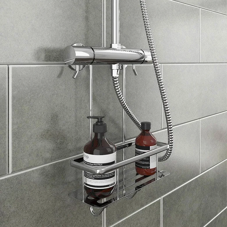 Chrome shower basket hanging from mixer valve pipework holding shampoo bottles