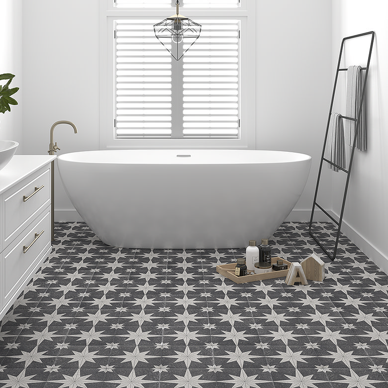Modern bathroom with freestanding bath, patterned floor tiles, white walls and brass bath tap