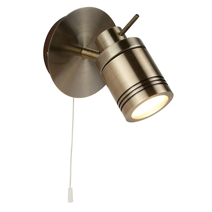 Brushed antique brass wall spotlight with adjustable head and pull cord switch, ideal for targeted bathroom or bedroom lighting.