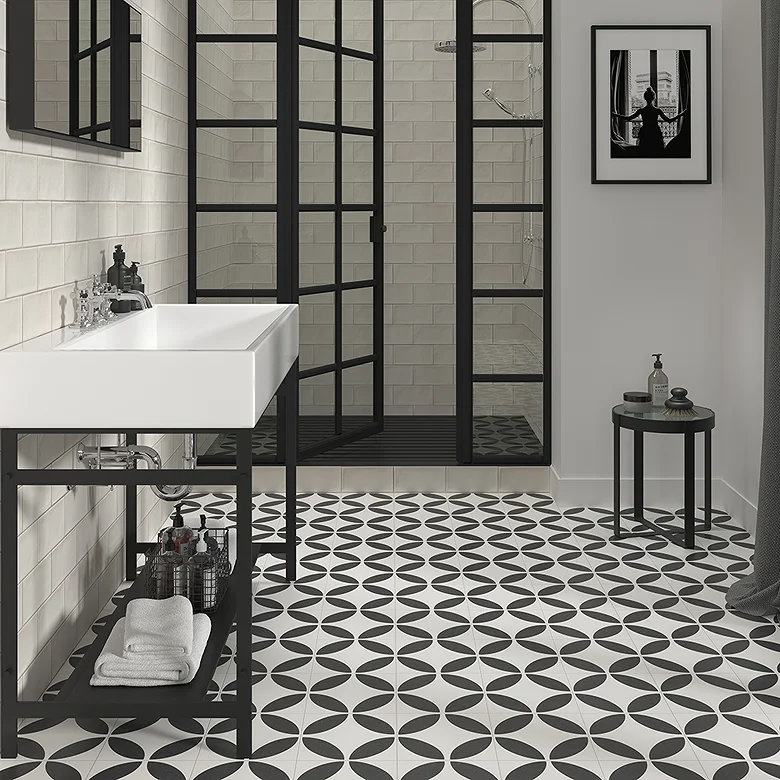 Black and white geometric patterned bathroom floor with black framed shower and white metro tile walls.