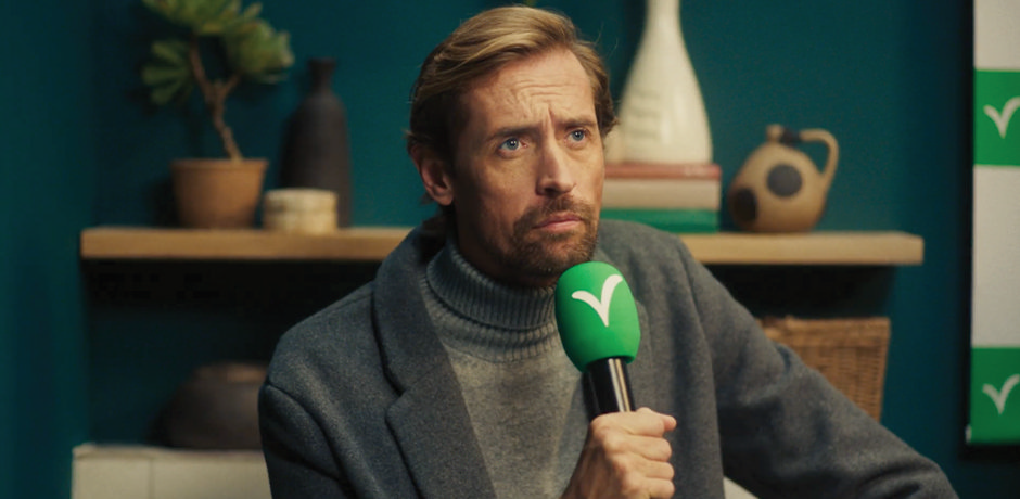 Peter Crouch holding a green Victorian Plumbing microphone during the Boss Your Bathroom campaign, blending football charm with stylish bathroom inspiration.