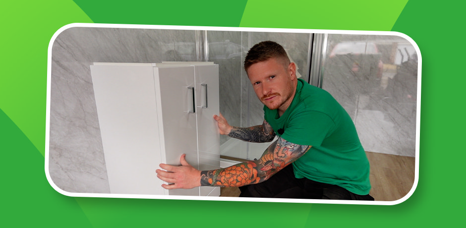 Plumber giving a final stability check to a newly installed white floor-standing vanity unit, ensuring doors align after fixing it to the bathroom wall
