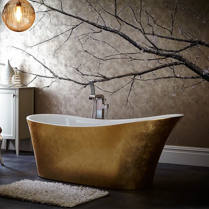 "Luxurious gold freestanding bathtub with modern chrome fixtures set against a wall featuring a delicate cherry blossom mural, with ambient pendant lighting and a soft shaggy rug on a dark wood floor.