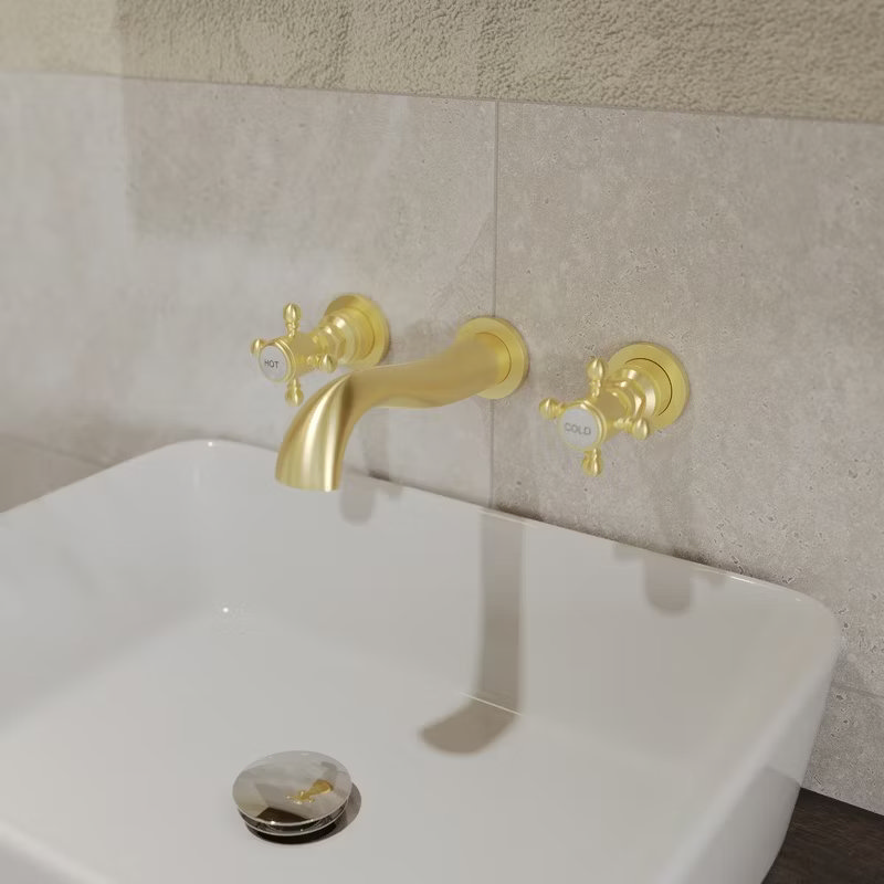 Close-up of elegant brushed gold wall-mounted taps paired with a white rectangular basin, adding a touch of luxury to the bathroom.