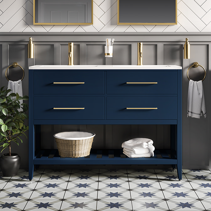 Indigo blue double vanity with brass handles in a Jack and Jill bathroom, featuring a slatted shelf and star-patterned tile floor