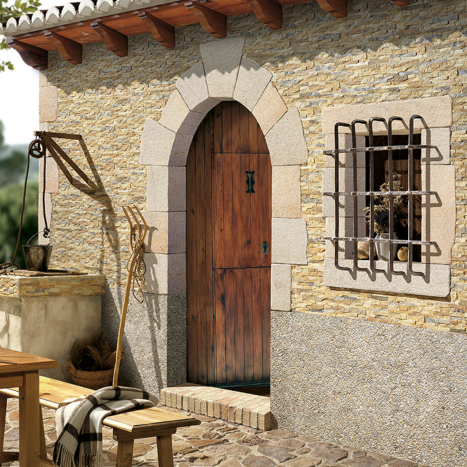 Silvetta Split Face natural stone-effect cladding on an exterior wall, adding warm texture and character to a rustic garden patio