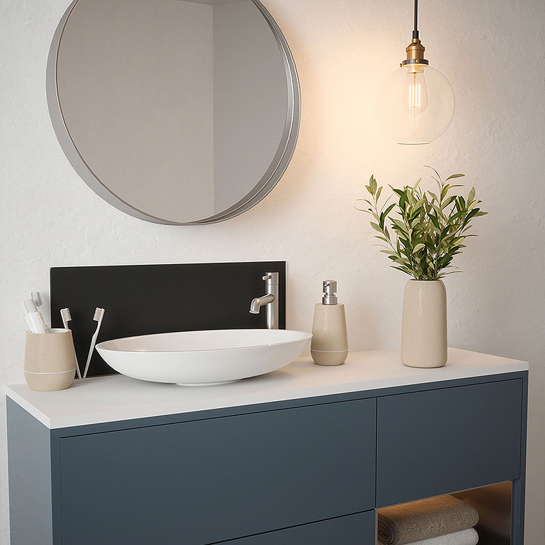 Modern bathroom vanity with a round vessel sink, brushed metal tap and a round mirror.