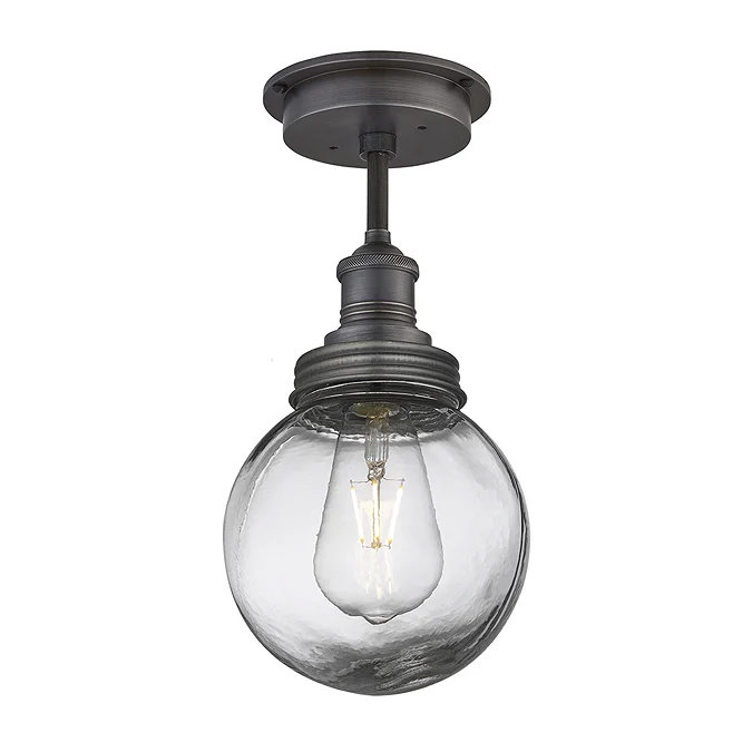 Industrial-style semi-flush ceiling light with a clear glass globe and vintage filament bulb, featuring a dark bronze finish.