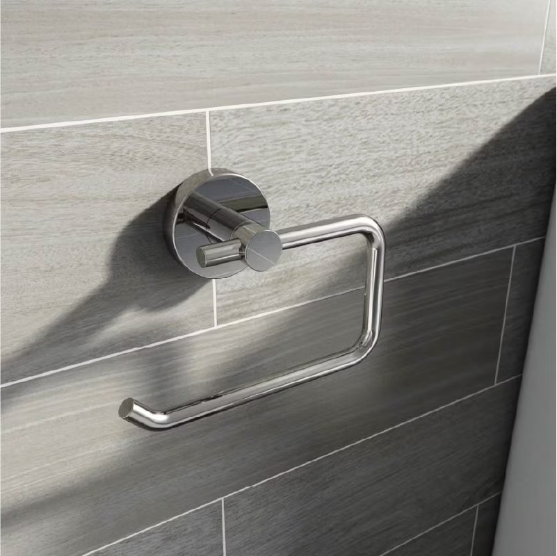 Modern chrome toilet roll holder mounted on grey tiled bathroom wall