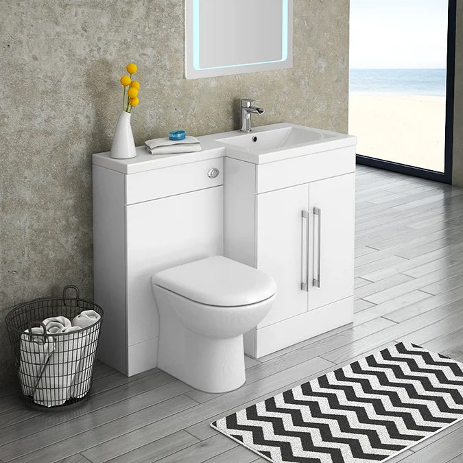 Space-saving toilet and sink combination unit in a small modern bathroom with a view of the beach, featuring a chevron rug and grey flooring