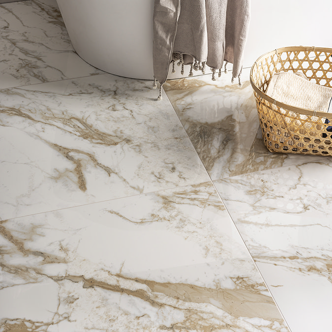 Glossy marble-effect floor tiles with beige veining, paired with a white bathtub and a wicker basket in a stylish bathroom.