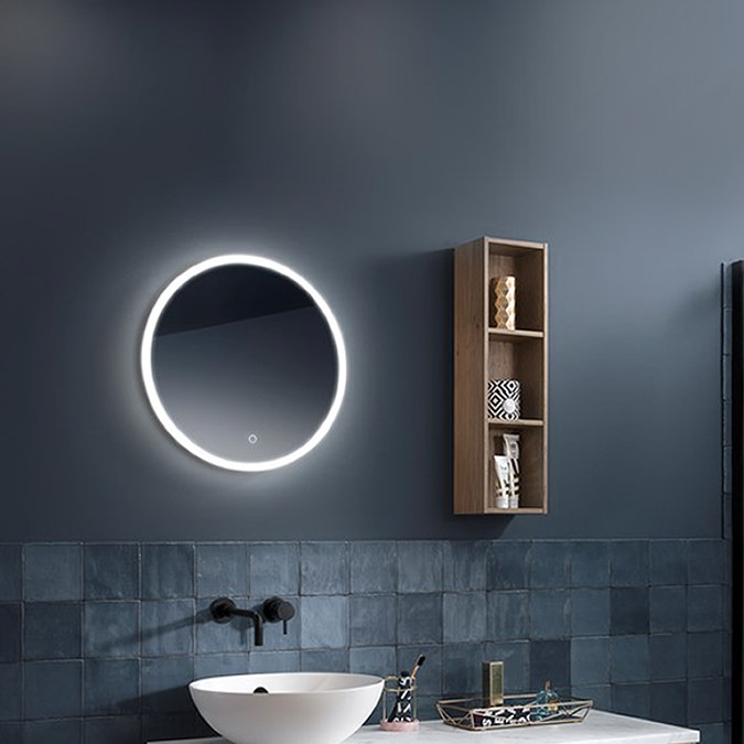 Modern bathroom with round LED mirror, dark tiles, and wooden wall shelf