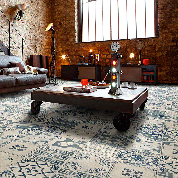 Industrial-style living room with rustic brick walls and durable ceramic floor tiles, featuring intricate blue and white vintage patterns. The ceramic tiles bring a mix of style and practicality to the room's warm, cosy ambiance.