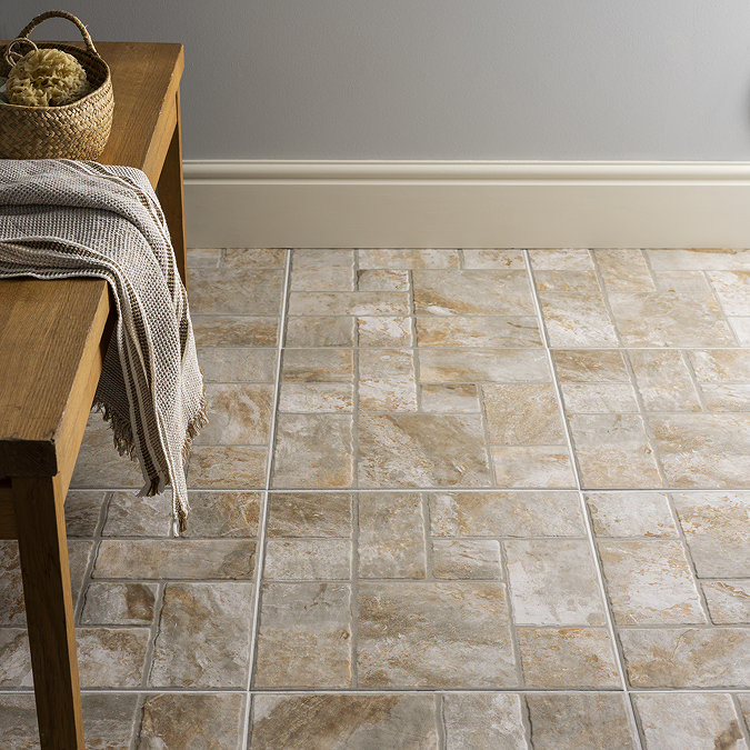 Textured stone-effect floor tiles in a warm, natural tone, paired with a wooden bench and woven basket, creating a cosy and rustic feel.