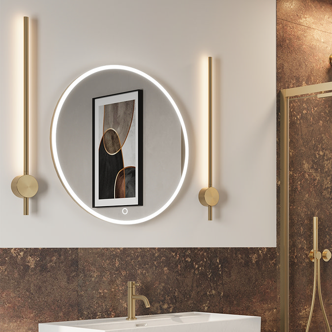 Contemporary bathroom setup featuring a circular LED-illuminated mirror with touch controls, flanked by sleek gold wall lights and complemented by a matching gold faucet and brown textured wall panels.