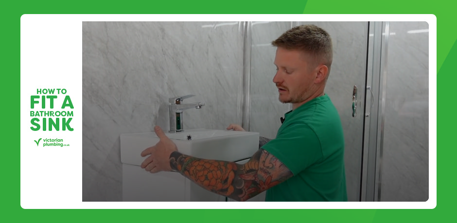 Installer aligning a bathroom sink onto a vanity unit during fitting