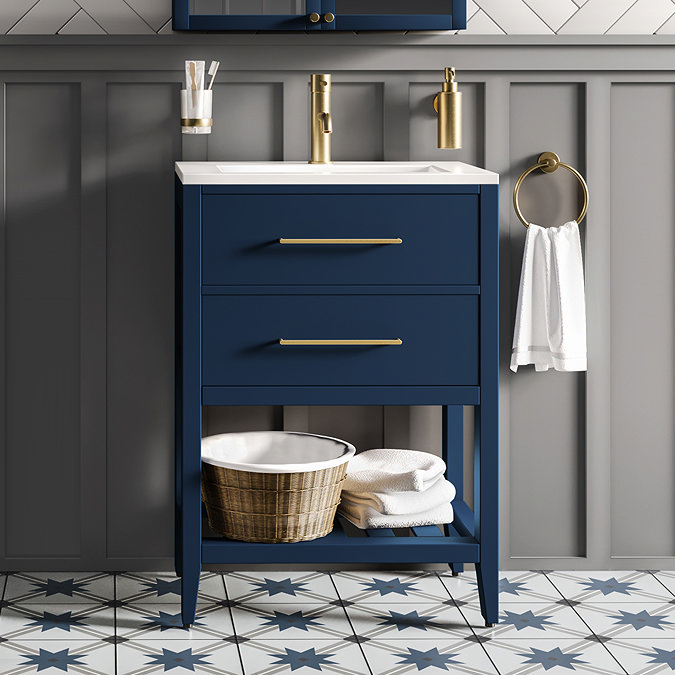 Elegant bathroom featuring a navy blue vanity unit with gold hardware, a gold wall-mounted tap, grey panelled walls, and star-patterned floor tiles.