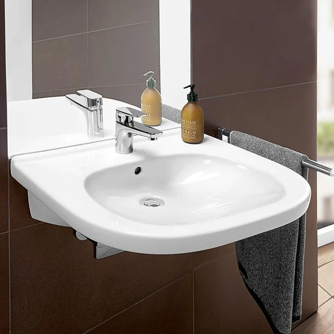 White semi-recessed bathroom basin with chrome mixer tap and towel rail.